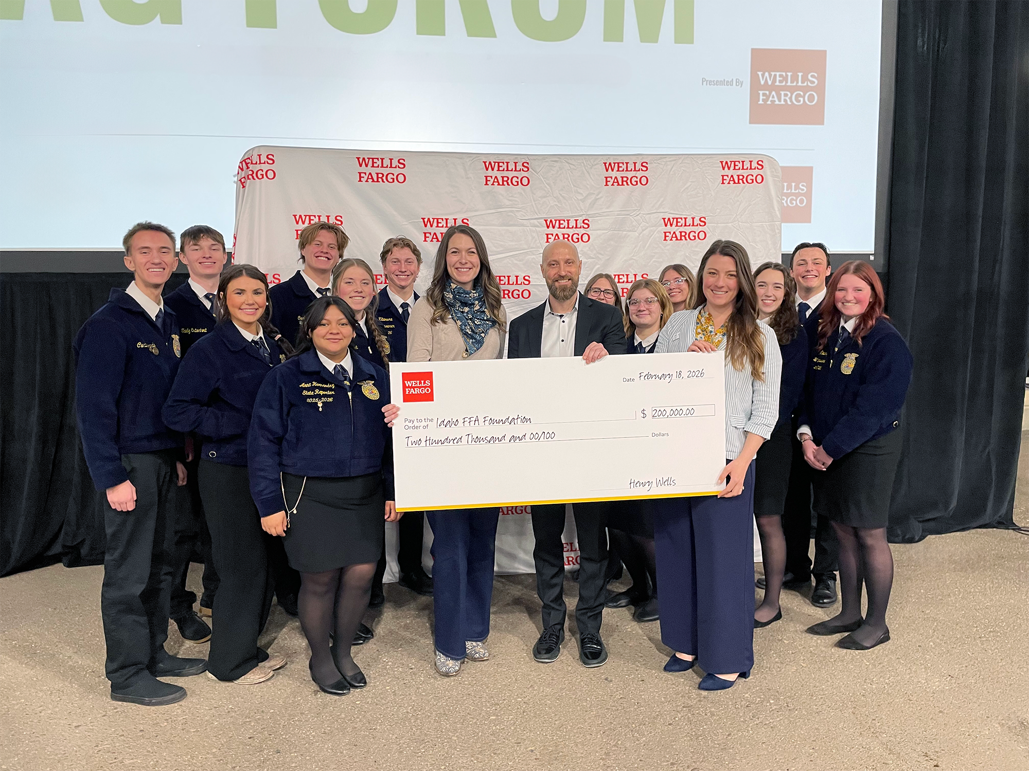 A group of FFA members and other people standing and smiling with a donation check